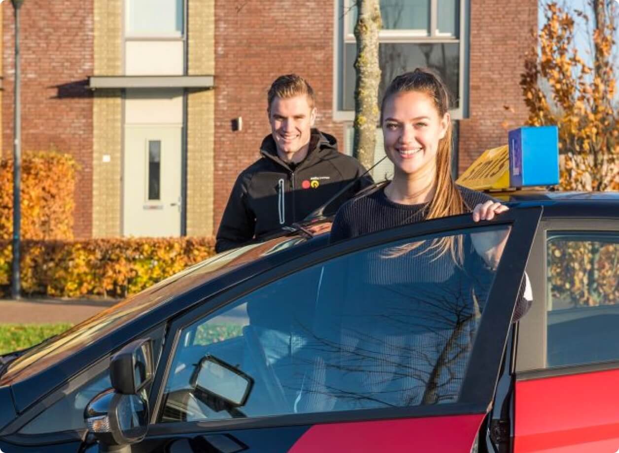 B Instructeur en Leerling staan bij de auto van Smits Opleidingen