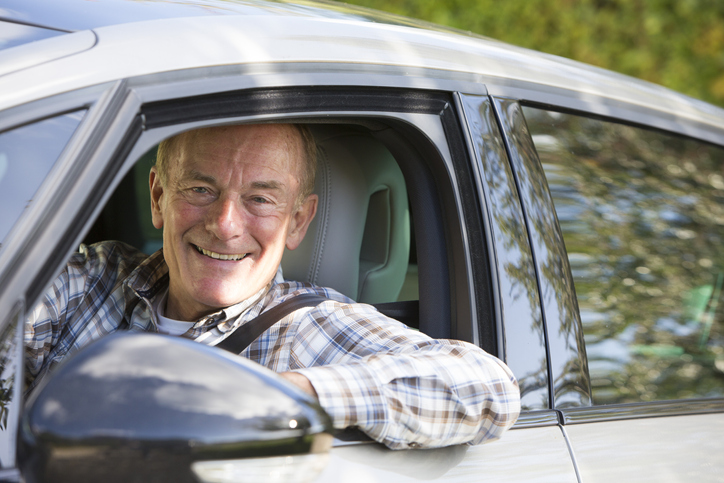 Oudere man rijdt in auto