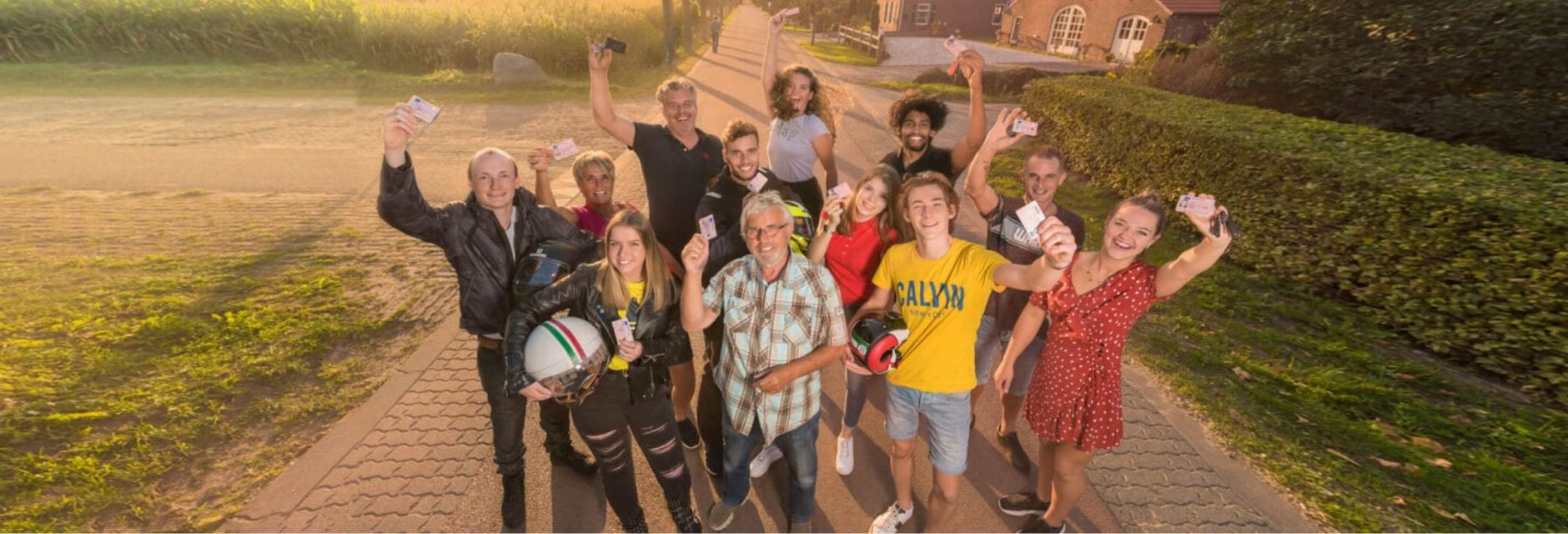 Geslaagden leerlingen bij elkaar die een rijbewijs aan de camera laten zien