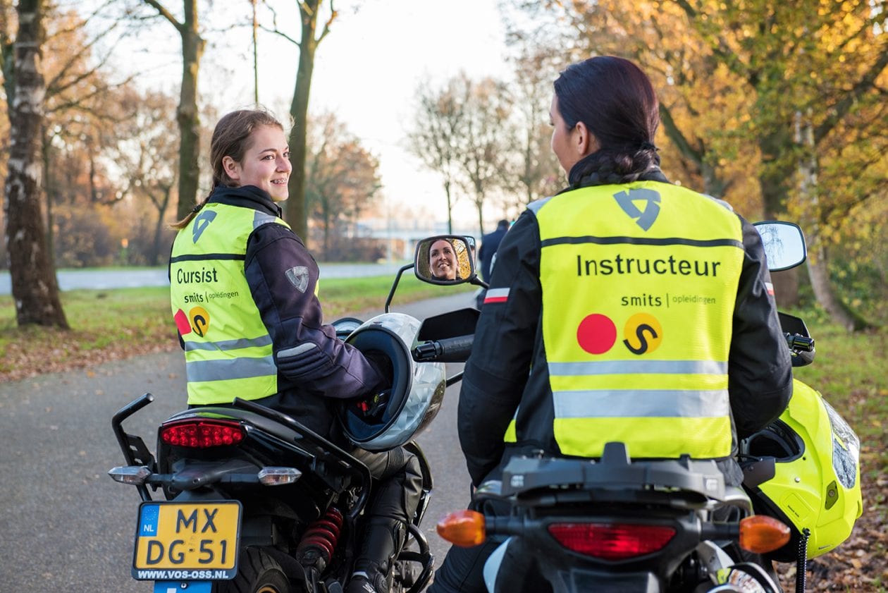 Instructeur en cursist naast elkaar op de motor