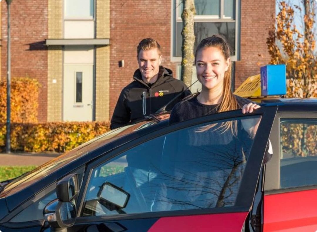 B Instructeur en Leerling staan bij de auto van Smits Opleidingen