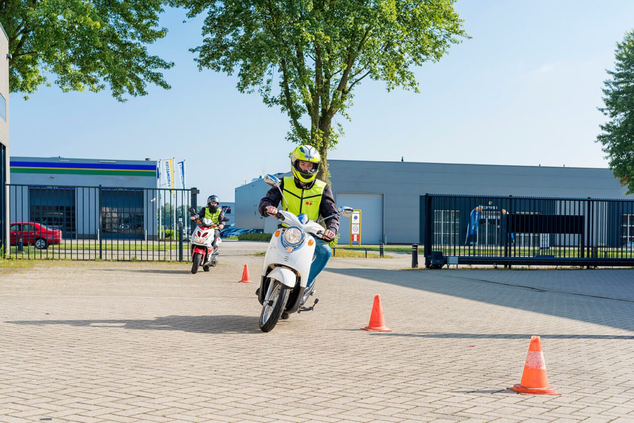 Een scooterleerling die aan het slalommen is