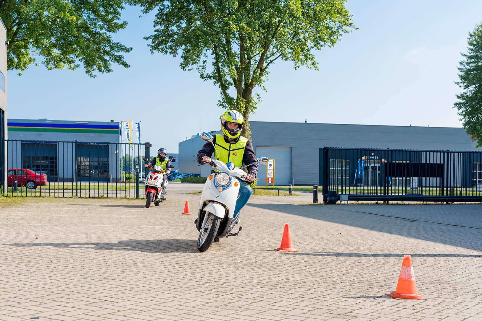 Een scooterleerling die aan het slalommen is
