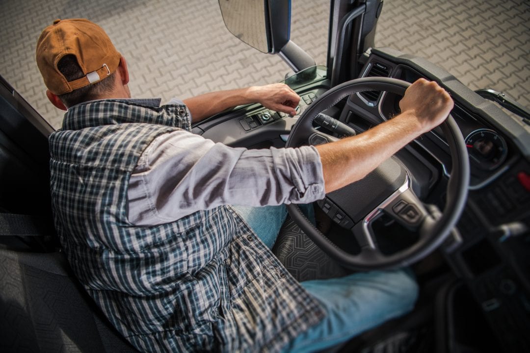 Vrachtwagenchauffeur die uit het raam van de truck kijkt