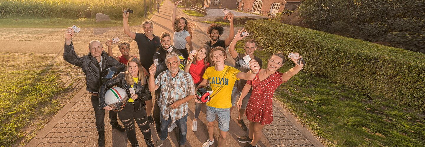 Geslaagden leerlingen bij elkaar die een rijbewijs aan de camera laten zien