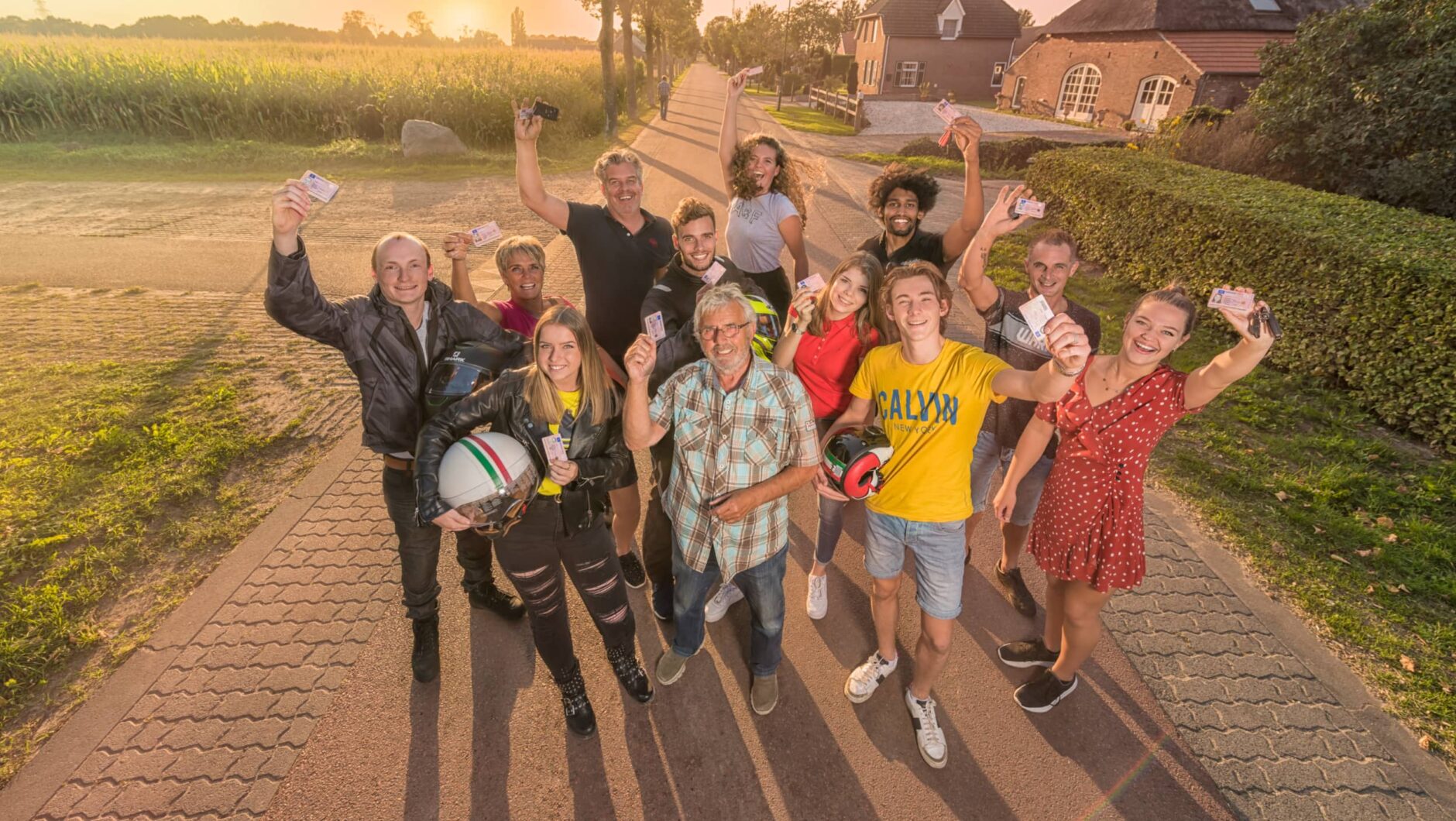 Geslaagden leerlingen bij elkaar die een rijbewijs aan de camera laten zien