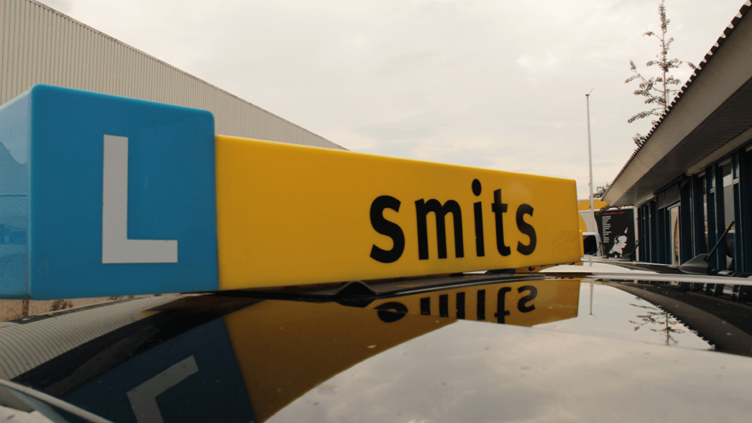 Het lesbord van Smits Opleidingen met daarop de tekst "Smits"